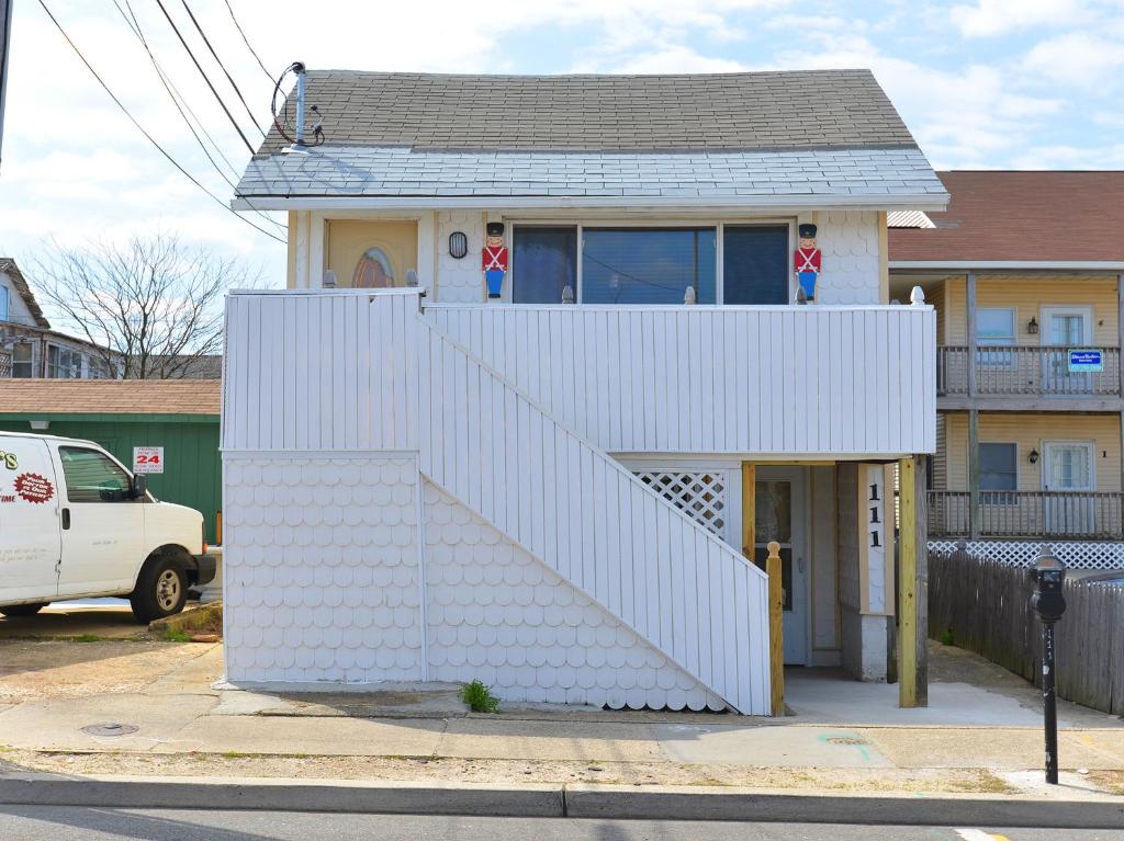 una casa blanca con una escalera delante en Shore Beach Houses - 111 Lincoln Ave, en Seaside Heights