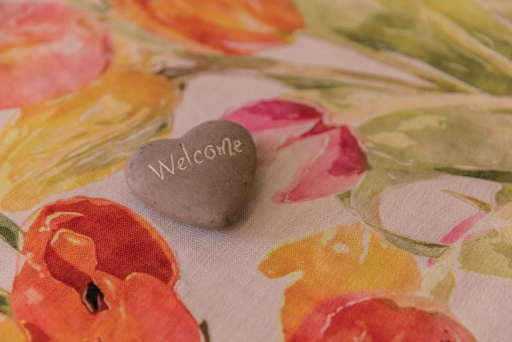 una roca con forma de corazón sentada en una tela con flores en Bauernhof Marquardt, en Fehmarn