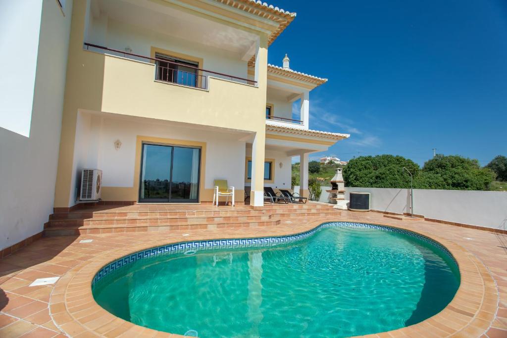 une villa avec une piscine en face d'une maison dans l'établissement Villa Vista Anders Mar, à Lagos