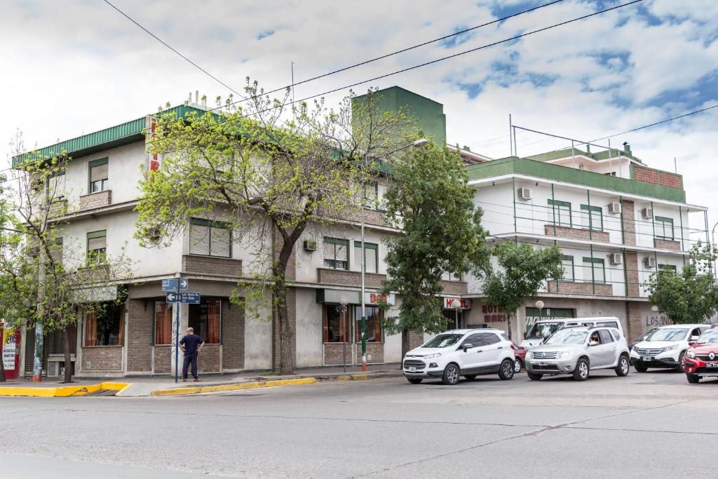 a building on the corner of a street with parked cars at Bari in Mendoza