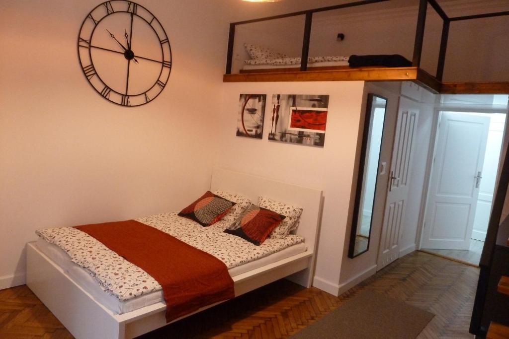 a bedroom with a bed with a large clock on the wall at City Space Apartments in Krakow