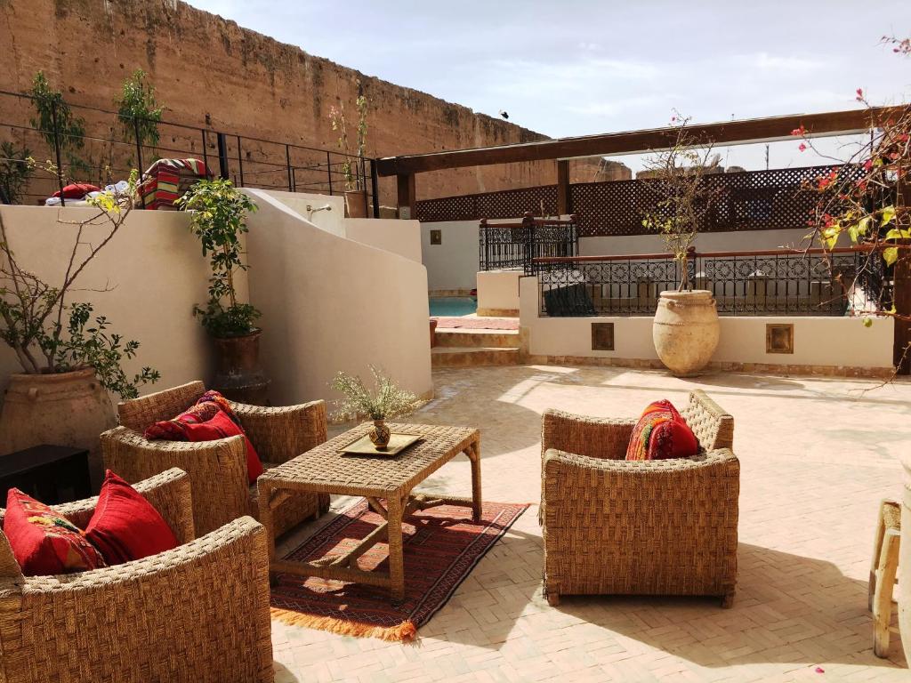 a patio with wicker chairs and a table on a patio at Riad Carina in Marrakesh