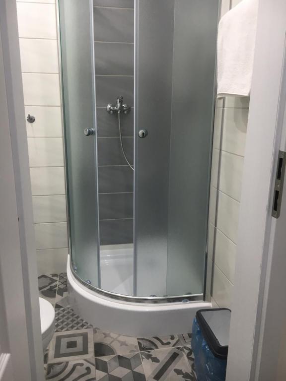 um chuveiro com uma porta de vidro na casa de banho em Apartman Saris em Presov