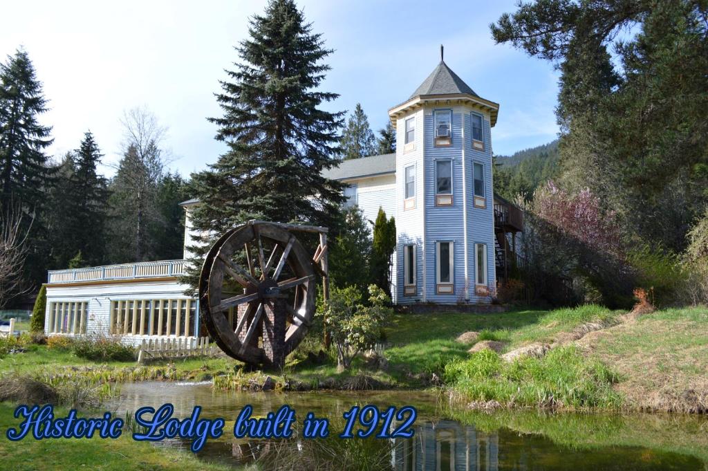 una casa grande con un molino de agua delante en Alexander's Lodge, en Ashford