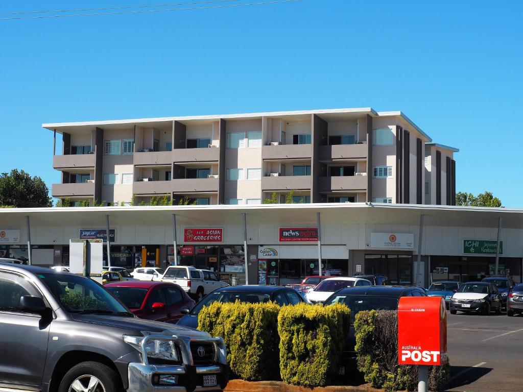 un estacionamiento con autos estacionados frente a un edificio en Laguna Serviced Apartments, en Toowoomba