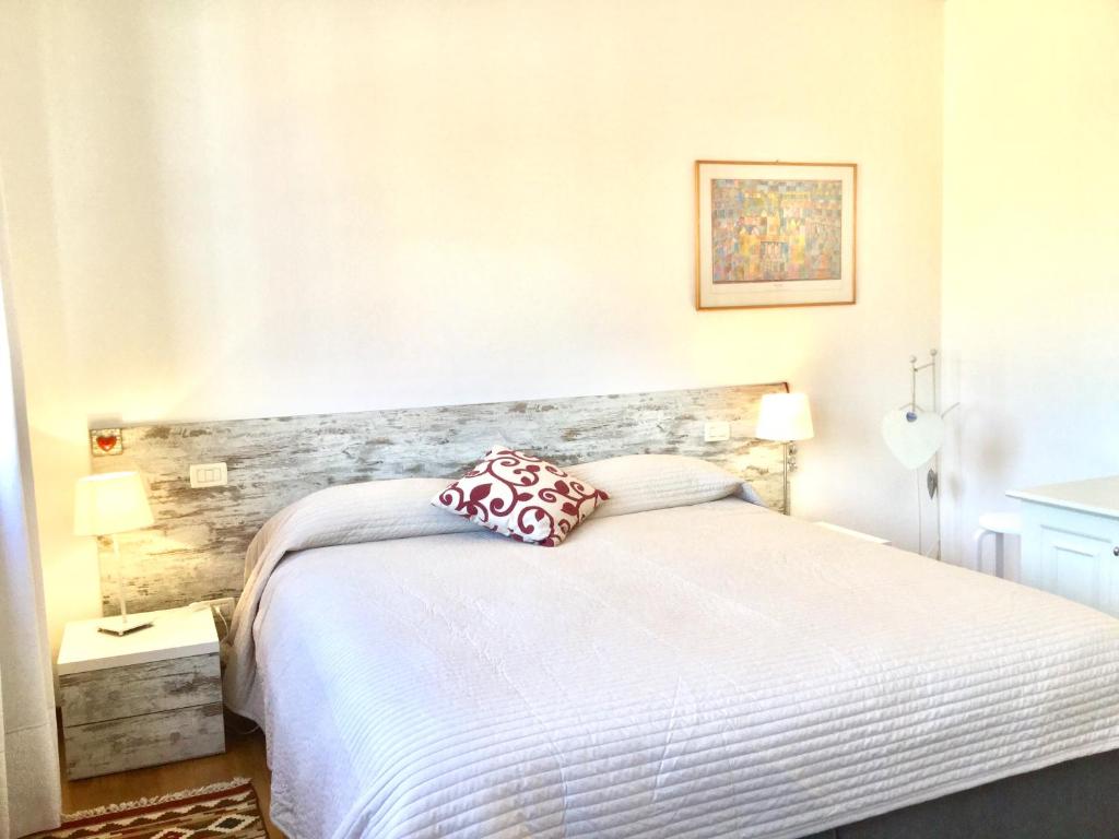 a bedroom with a white bed with a red pillow at Giudecca View in Venice