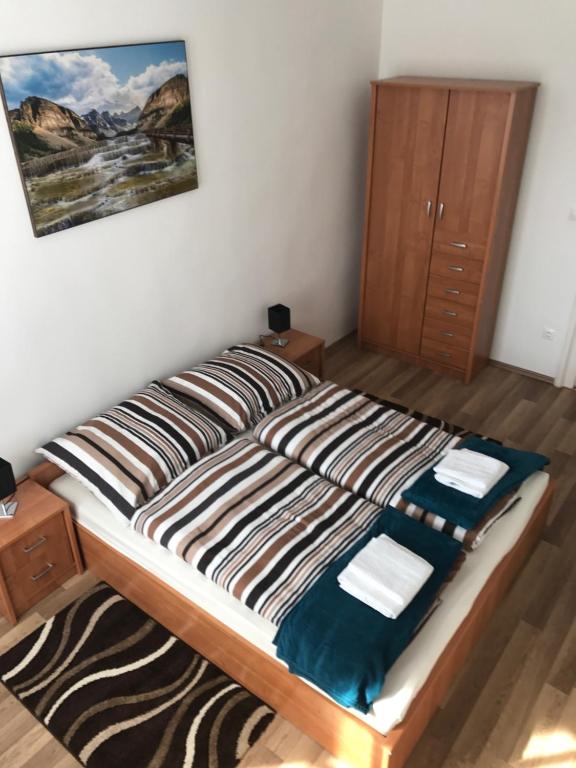 a bedroom with a large bed with a wooden cabinet at Éva Apartman in Miskolc