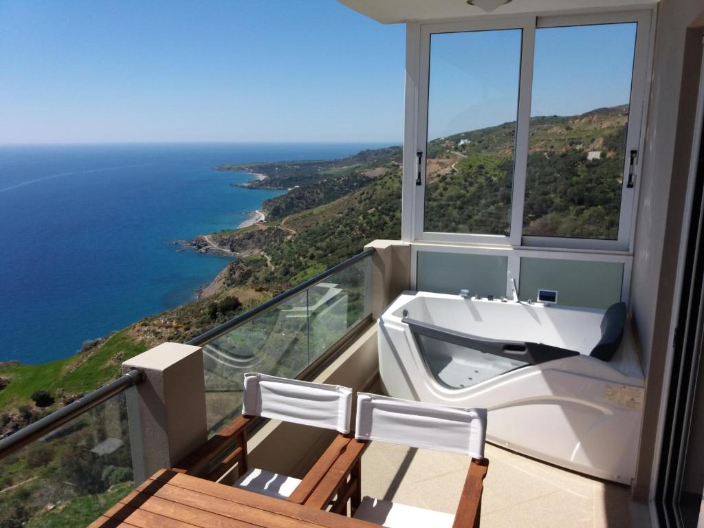 a bathroom with a tub and a view of the ocean at Akrotiri Panorama - luxury apartments with sea view in Rodakino