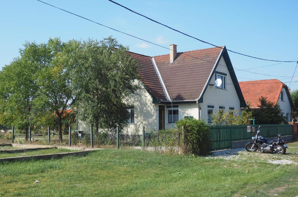 a house with a motorcycle parked in front of it at Privatzimmer Csikos in Hortobágy