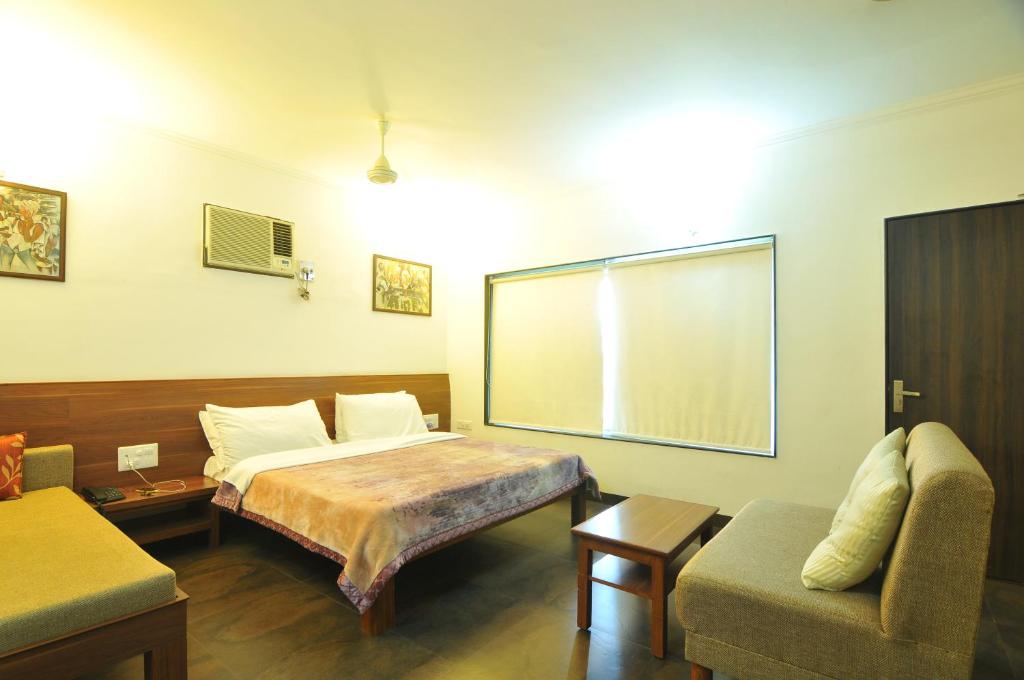 a room with a bed and a couch and a window at Lago villa in Bhopal