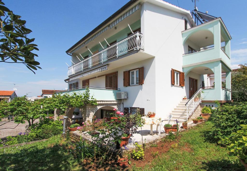 a large white building with stairs and balconies at Apartments Silvia in Poreč