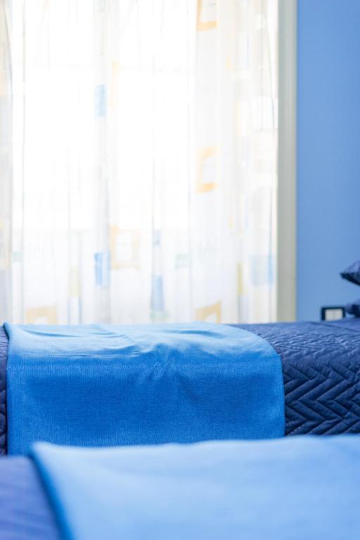 a blue blanket on a bed with a window at B&B 'O Sole Mio! in Naples