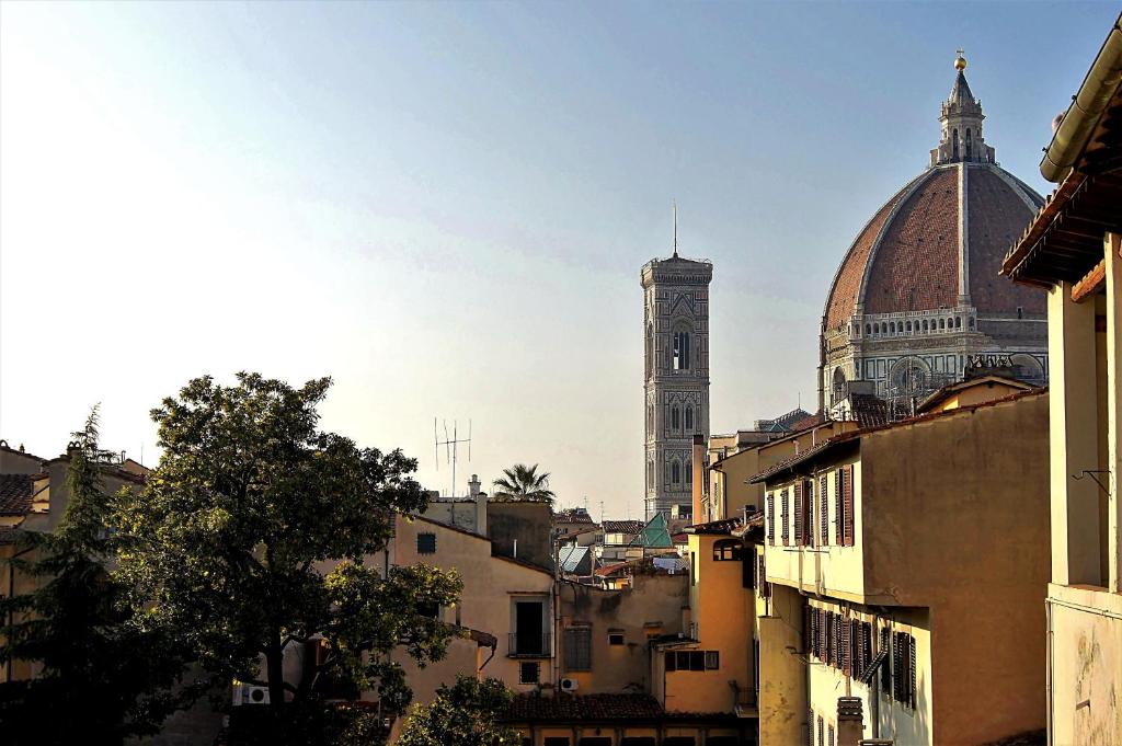 un bâtiment avec une tour de l'horloge et une cathédrale dans l'établissement Appartamenti Oriuolo, à Florence