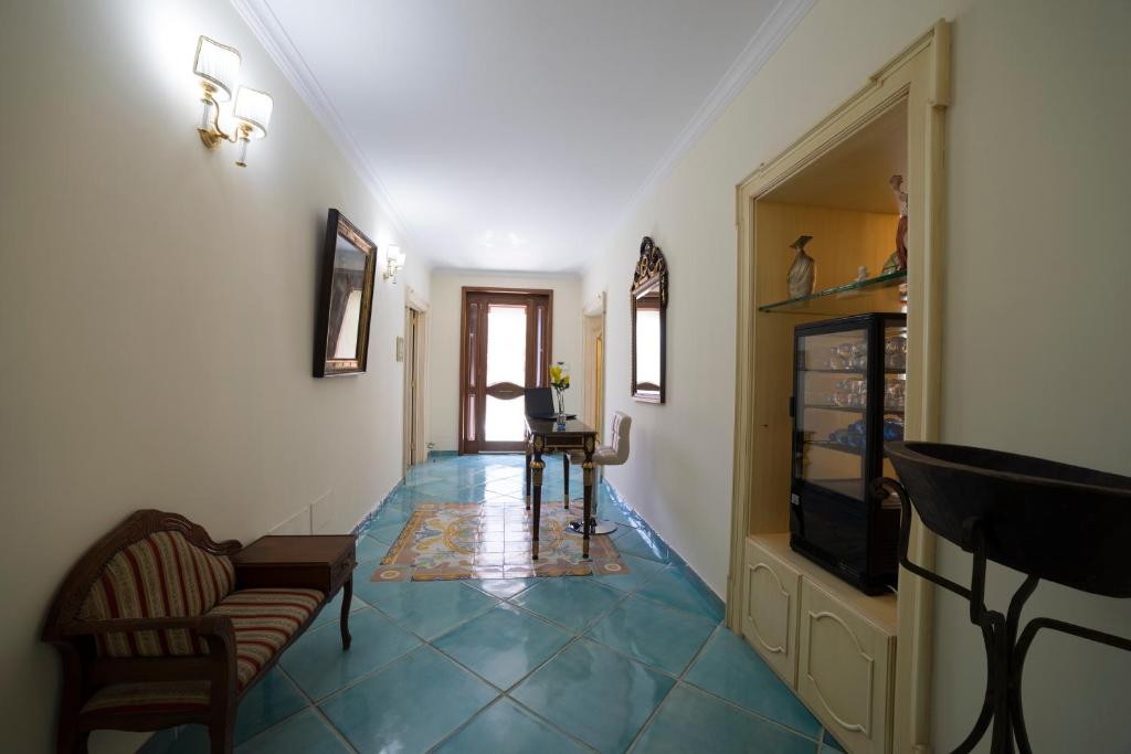 a hallway with a blue tile floor and a television at B&B 'O Sole Mio! in Naples