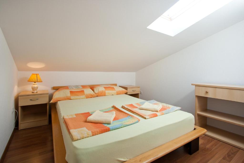 a bedroom with a bed with two pillows on it at Apartments Špadići in Poreč