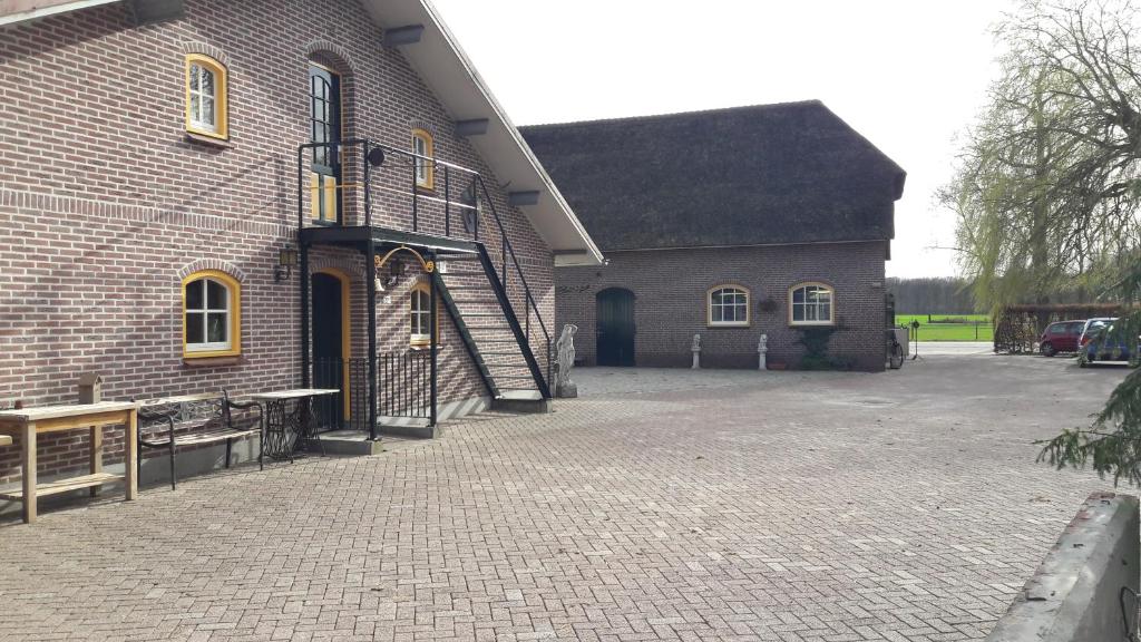 um grande edifício de tijolos com uma entrada em frente em Herberg de Brand em Udenhout