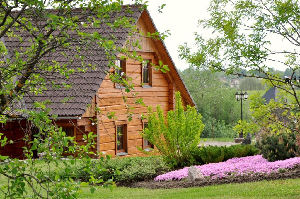 a log cabin with a garden in front of it at Pie Pētera in Cēsis