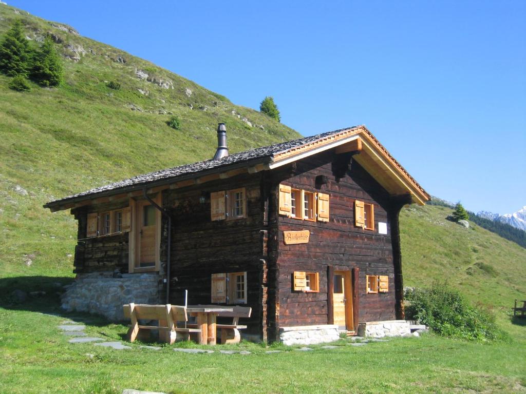 フィエッシュにあるAlphütte Bielerhüsの草の丘のある小さな木造家屋