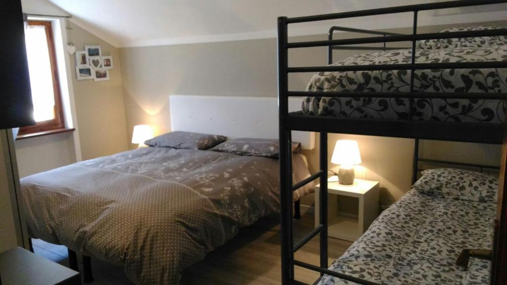 マレスコにあるAppartamento Maury Locazione Turisticaのベッドルーム1室(二段ベッド2組、ベッド1台付)