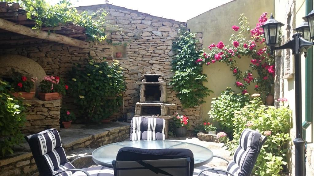 un patio con mesa, sillas y flores en Casa Rural Zapatero en Trabanca