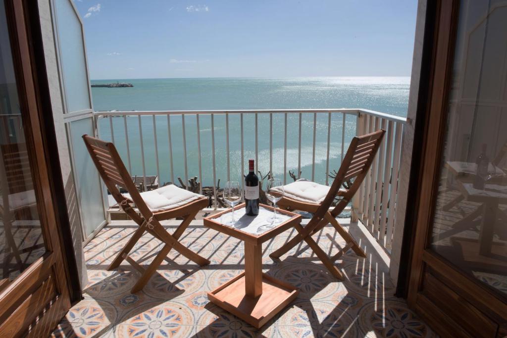 a table and two chairs on a balcony with the ocean at Appartamento Mare Blu in Sciacca