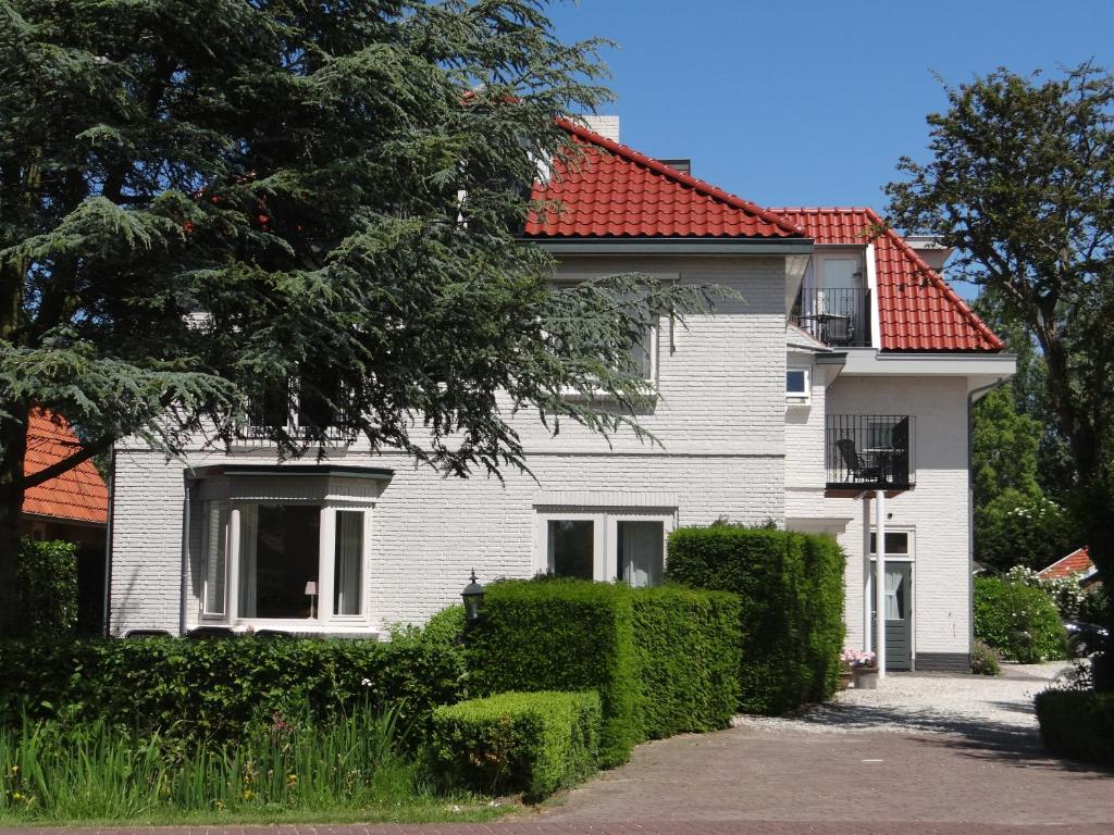 ein weißes Haus mit rotem Dach in der Unterkunft De Wentehoeve in Oostkapelle