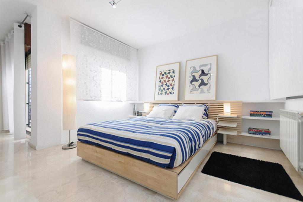 グラナダにあるAFAN Granada y PARKING incluidoのベッドルーム1室(青と白のストライプの毛布付きのベッド1台付)