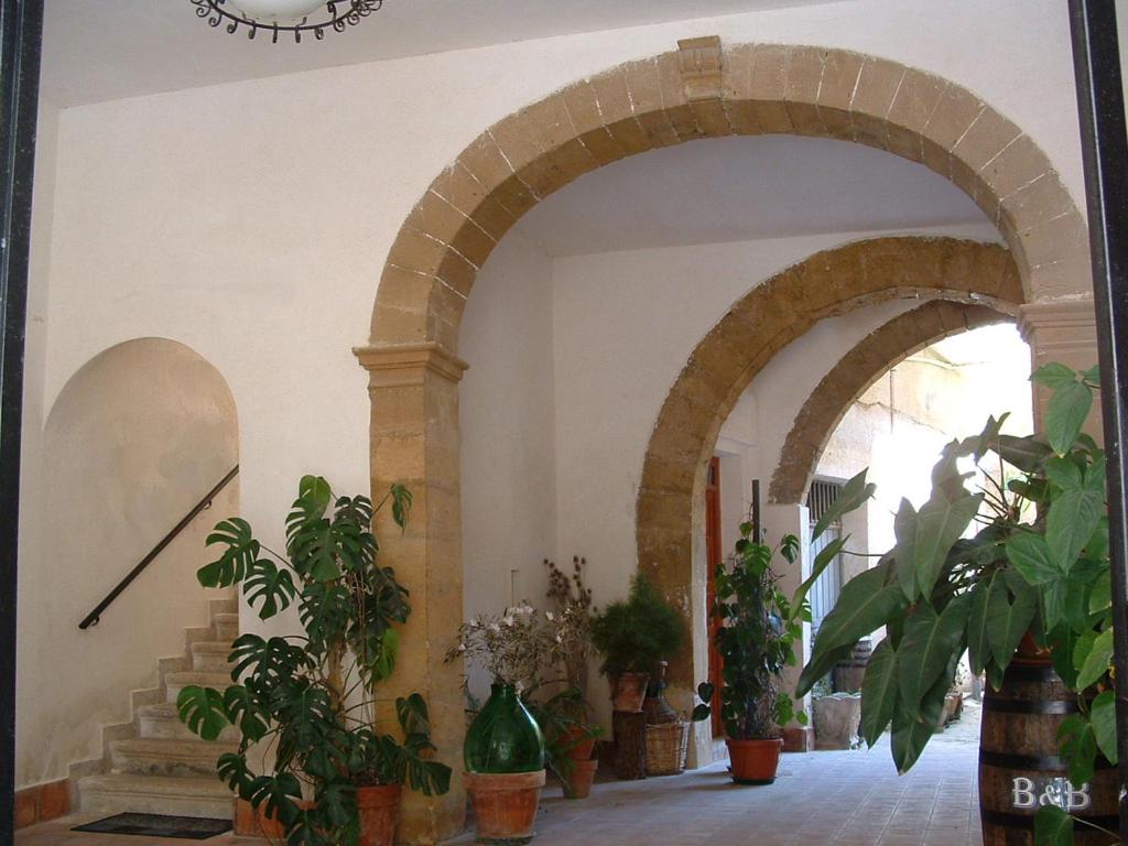 un arco en un edificio con macetas en La Corte di Zaccaria, en Mazara del Vallo
