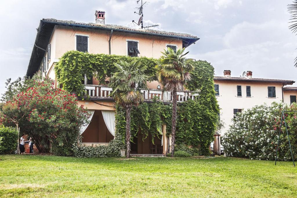 una grande casa con edera sul lato di La Villa del Lago a San Felice del Benaco