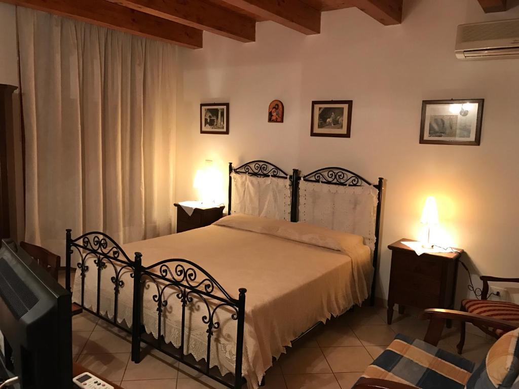 a bedroom with a bed and two tables and two lamps at Sikè Appartamenti in Siracusa