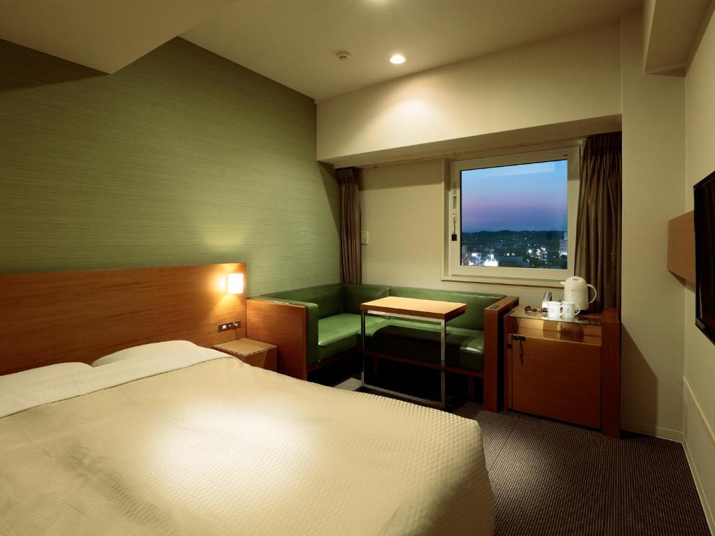 Un pat sau paturi într-o cameră la Candeo Hotels Handa