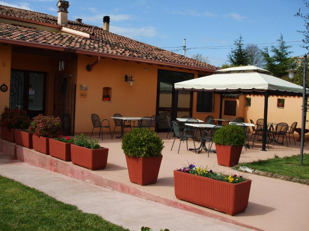 um pátio exterior com mesas, cadeiras e plantas em Agriturismo Nuvolino em Monzambano