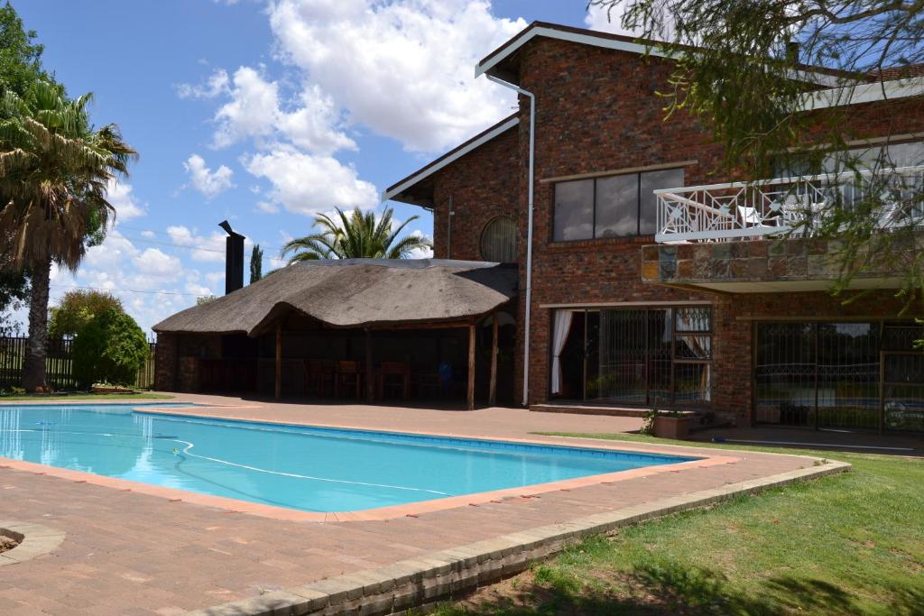 a house with a swimming pool in front of a house at Krige Lodge B&B in Bloemfontein