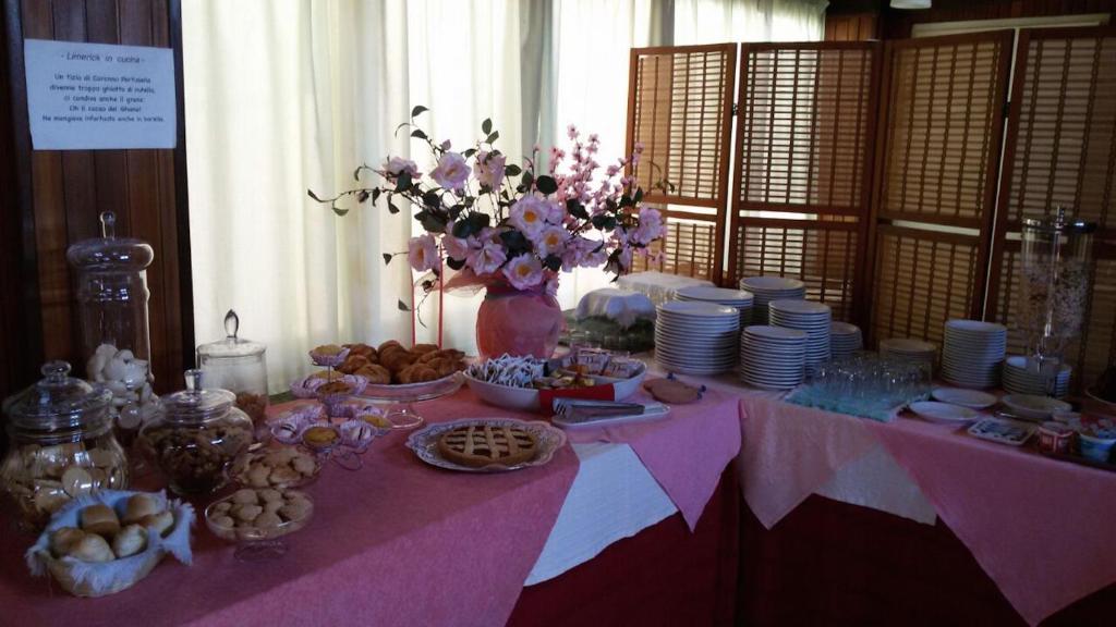 a table with a pink table cloth with food on it at Hotel Signorini in Castiglioncello