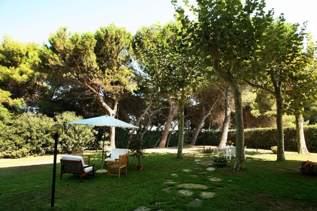 a yard with a table and chairs and an umbrella at B&B Il Parco Dei Pini in Giulianova