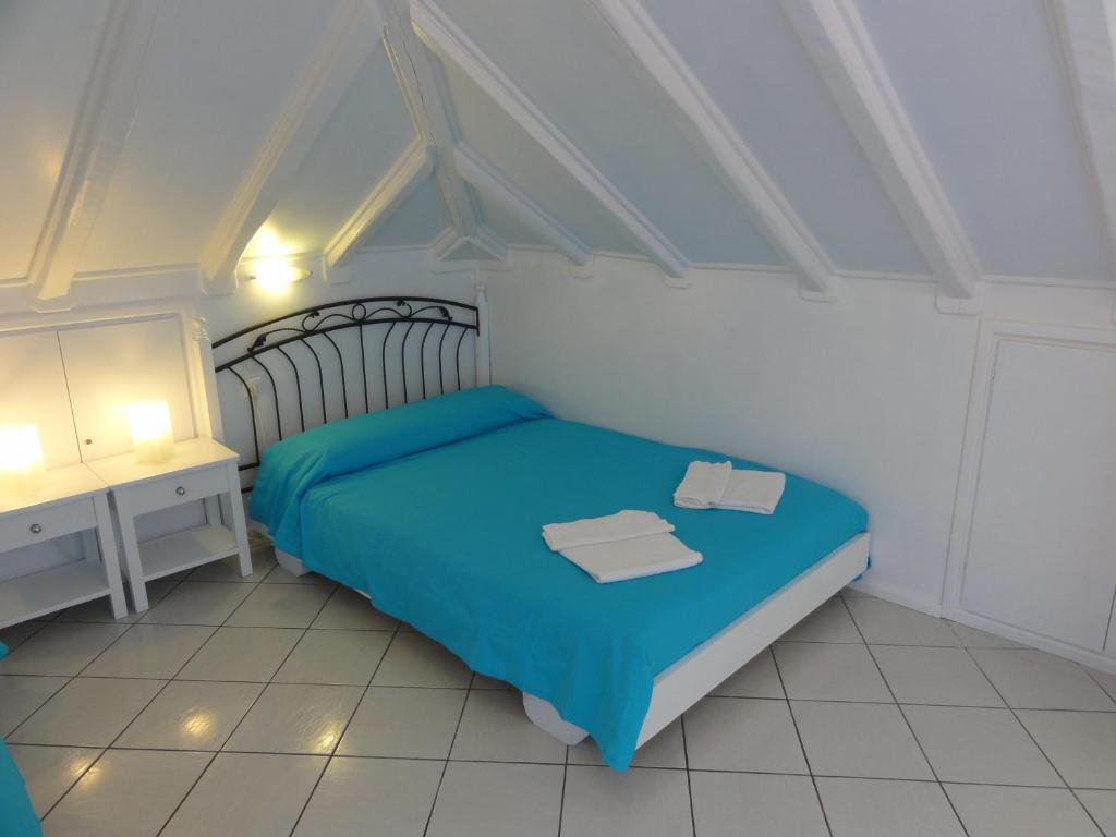 a small bedroom with a blue bed and a desk at Botsis Guest House in Hydra