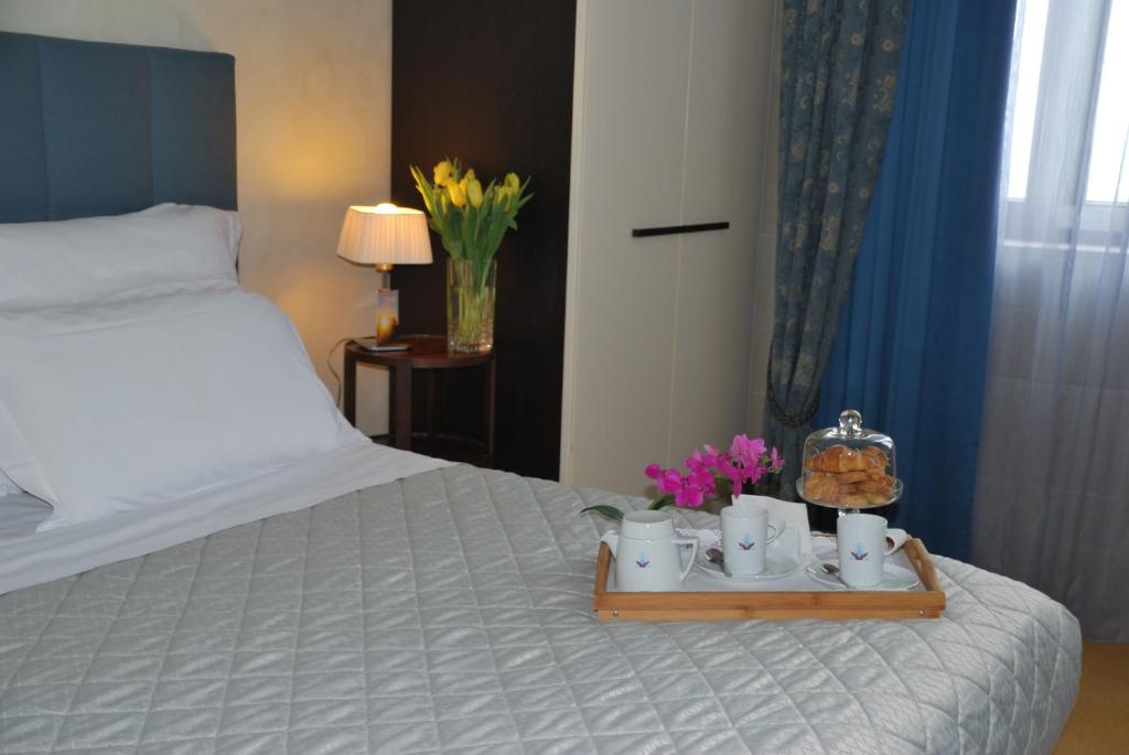 a bed with a tray with cups and flowers on it at Domus Mariae Benessere in Siracusa