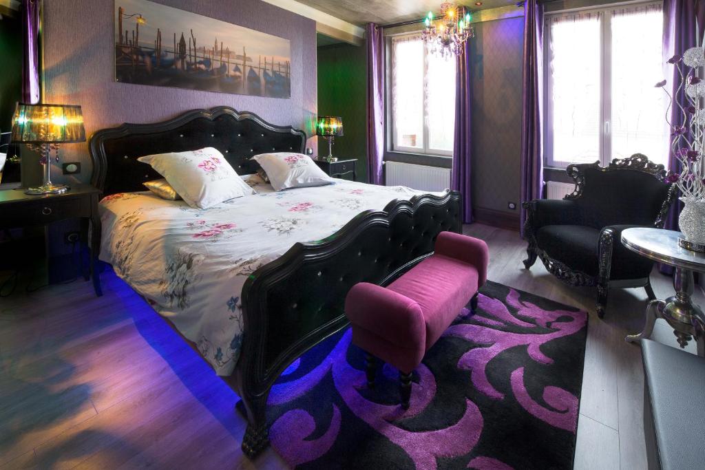1 dormitorio con 1 cama grande y 1 silla rosa en Chambres d'hôtes & Gîtes La Paysanne, en Fresnes-en-Woëvre