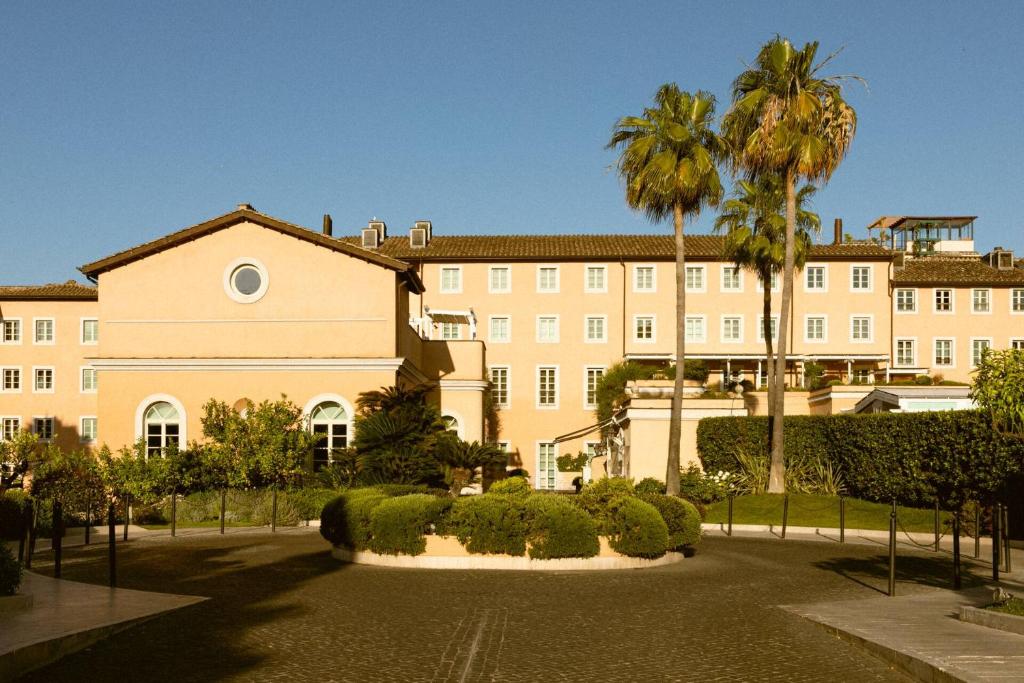 a large building with palm trees in front of it at Villa Agrippina, a Gran Meliá Hotel - The Leading Hotels of The World in Rome