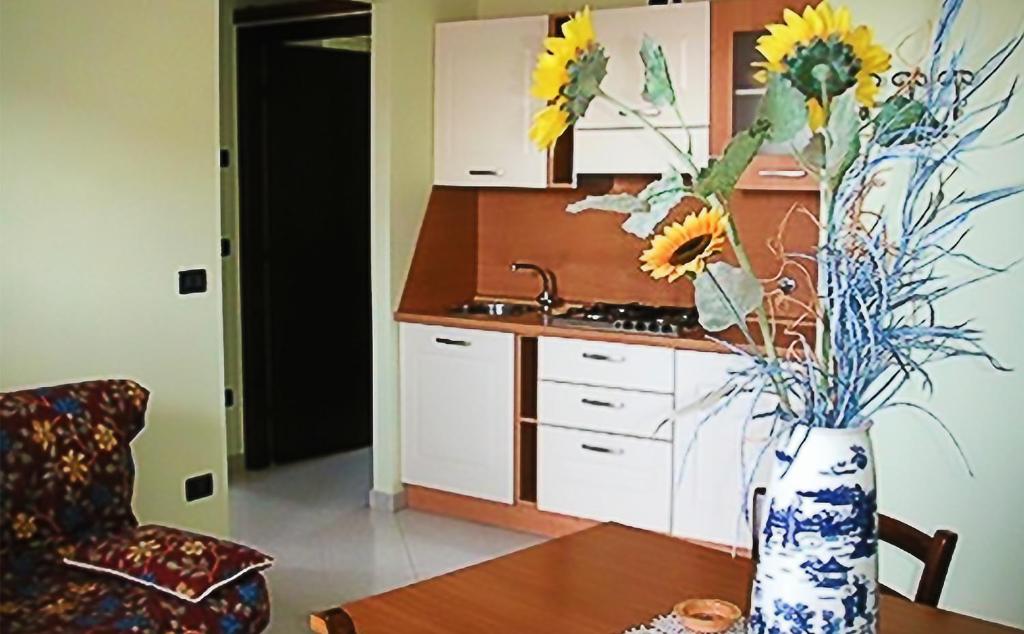 una cucina con un vaso e fiori su un tavolo di Il Piccolo Residence ad Acquaviva