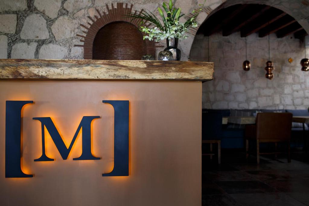 a sign that says m on a counter in a room at Maja Hotel Boutique in Morelia