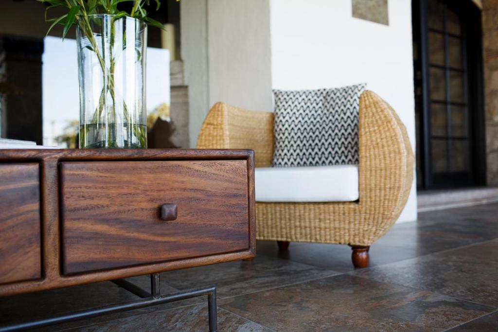 a wicker chair and a table with a vase on it at Maja Hotel Boutique in Morelia