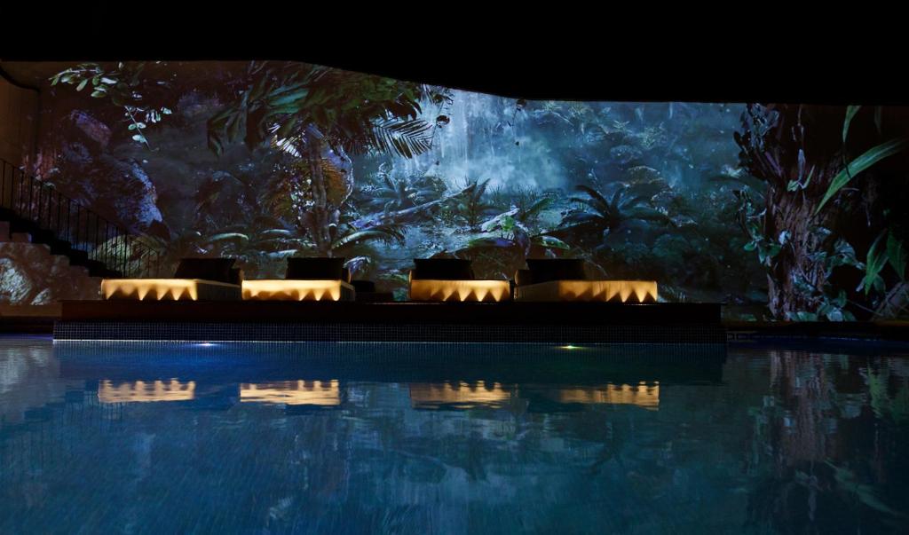 a swimming pool in front of a large aquarium at Maja Hotel Boutique in Morelia