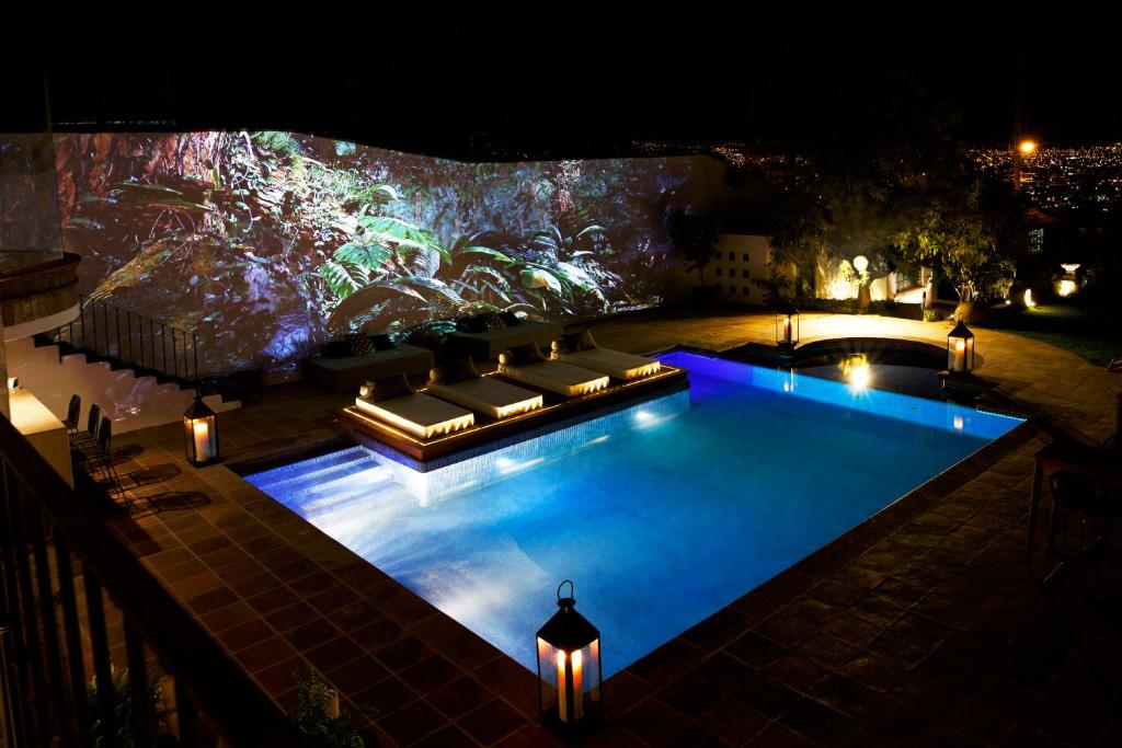 a swimming pool at night with a couch and lights at Maja Hotel Boutique in Morelia