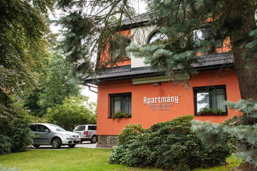 a red building with a sign on the side of it at Apartmány U Červeného stromu in Rožnov pod Radhoštěm