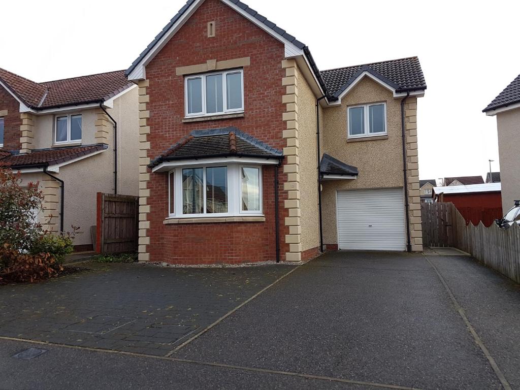 a red brick house with a white garage at Jane's Villa Free Parking in Inverness