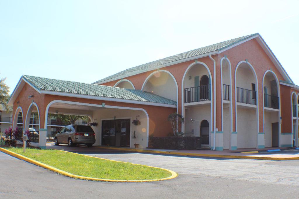 een gebouw waar een auto voor geparkeerd staat bij Shining Light Inn & Suites in Kissimmee