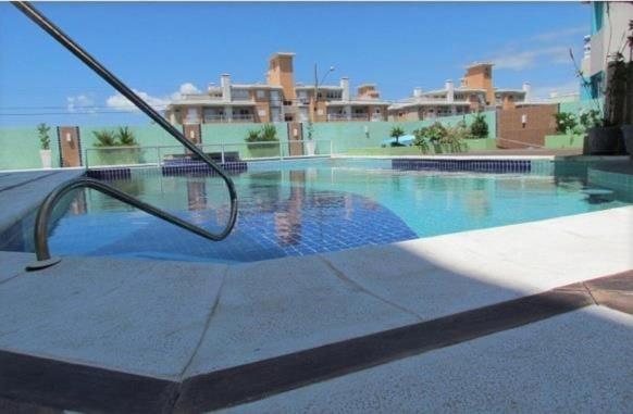 una piscina con un pasamanos de metal al lado de un edificio en Flat Estrela do Mar Oficial, en Florianópolis
