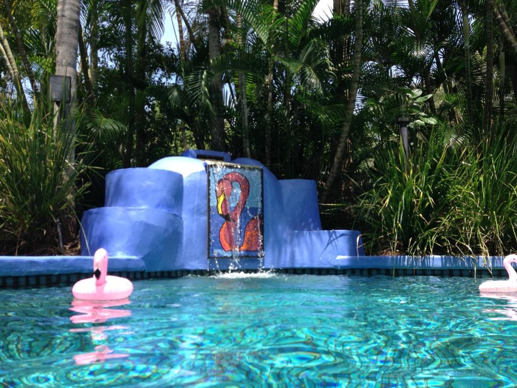 a water slide in a pool with pink flamingos at Pink Flamingo Resort in Port Douglas