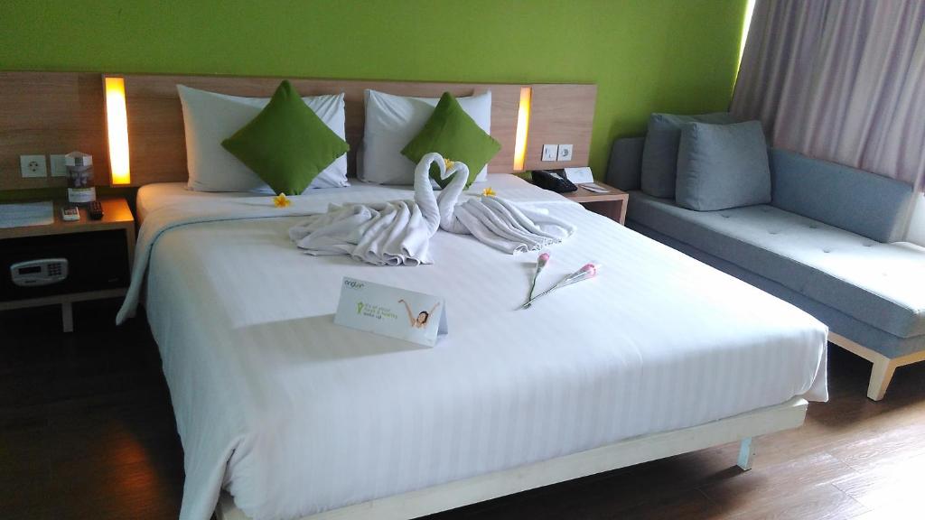 Postel nebo postele na pokoji v ubytování Whiz Prime Hotel Pajajaran Bogor